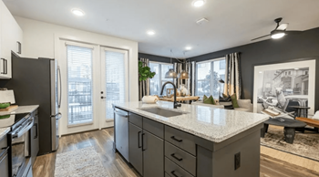 A modern kitchen with a large island and stainless steel appliances.